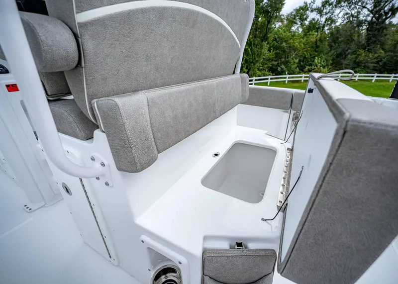 Slide: The Image of 2025 Sea Hunt Ultra 239 SE boat seating with storage compartment open. - 11