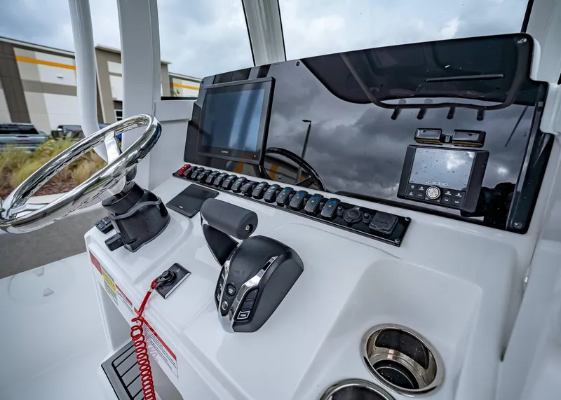 Slide: The Image of 2025 Sea Hunt Ultra 239 SE boat dashboard with steering wheel and electronic controls. - 13