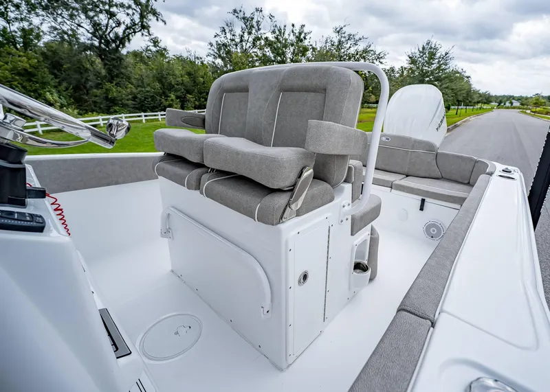 Slide: The Image of 2025 Sea Hunt Ultra 239 SE boat interior with cushioned seating and steering console. - 15