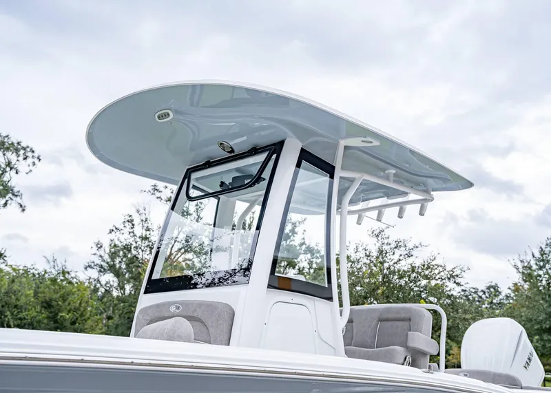Slide: The Image of 2025 Sea Hunt Ultra 239 SE boat with sleek T-top design against cloudy sky. - 2