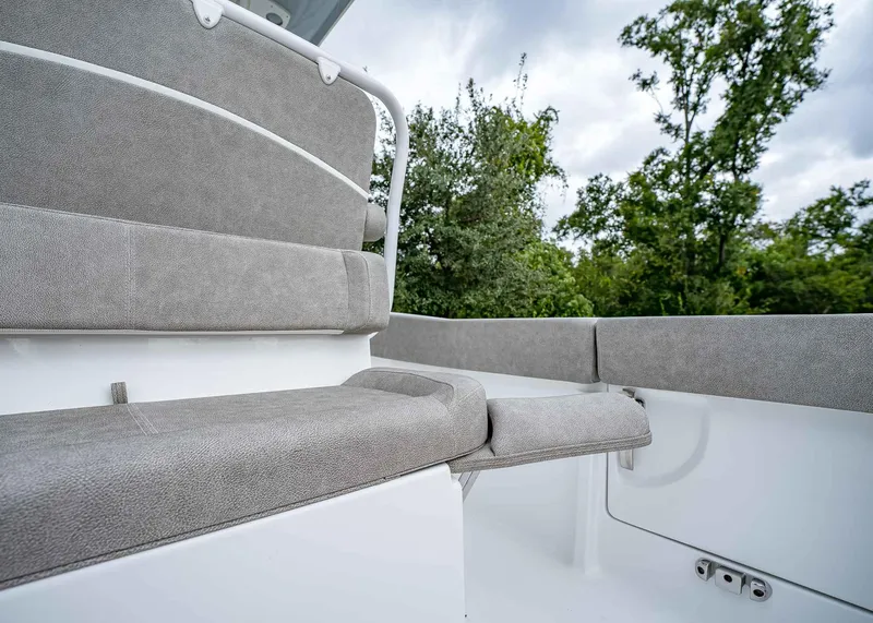 Slide: The Image of 2025 Sea Hunt Ultra 239 SE boat interior with gray seating and lush greenery background. - 8