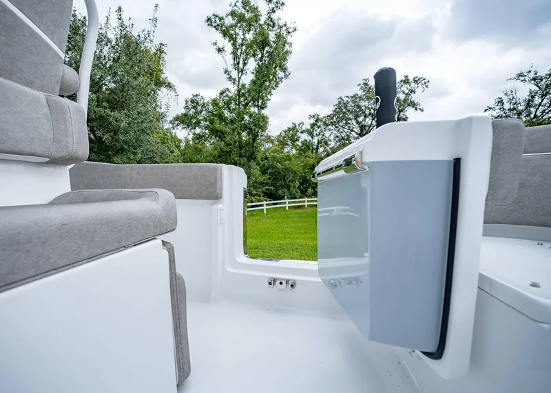 Slide: The Image of 2025 Sea Hunt Ultra 239 SE boat interior with gray seating and lush greenery background. - 9