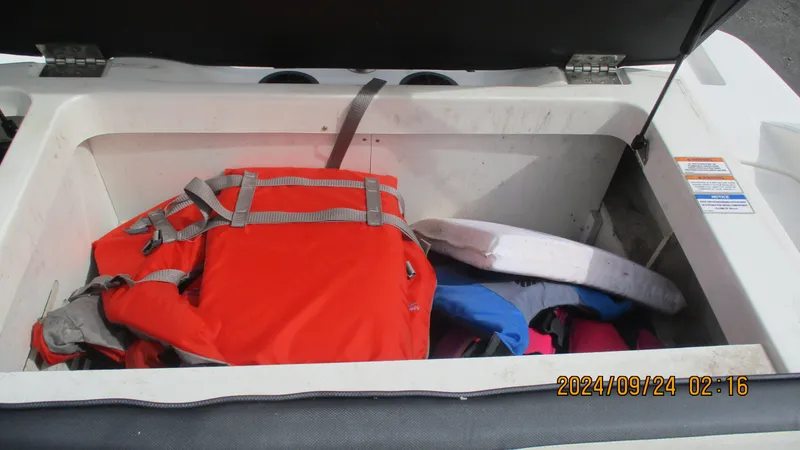 Slide: The Image of Storage compartment of 2016 Sea Ray 21SPX-OB with life jackets and safety gear. - 18