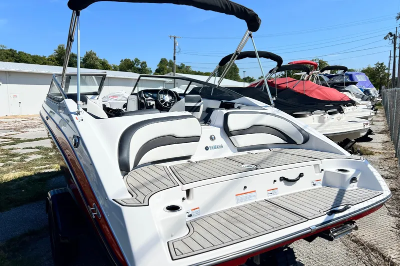 Slide: The Image of 2021 Yamaha Boats SX195, sleek design, docked outdoors, showcasing rear seating and deck. - 11