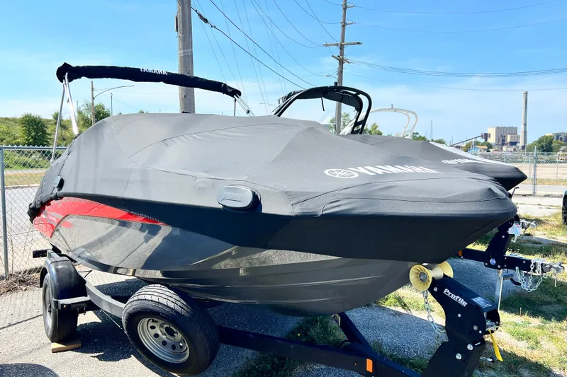 Slide: The Image of 2021 Yamaha Boats SX195 covered on trailer, parked outdoors. - 21