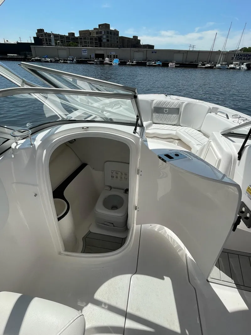 Slide: The Image of 2024 Sea Fox 228 Traveler boat interior with open cabin and toilet, docked at marina. - 12