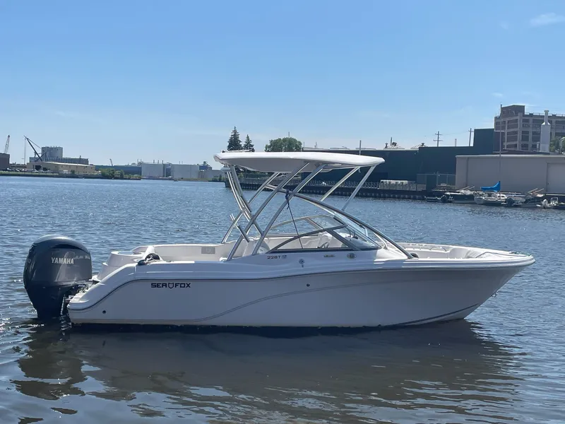 Slide: The Image of 2024 Sea Fox 228 Traveler boat on calm water, featuring a Yamaha outboard motor. - 2