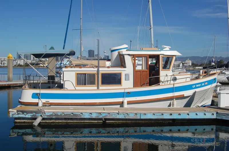 The Image of 1985 Sundowner Tug Princess Louisa docked at marina, featuring classic design and blue accents. - 0