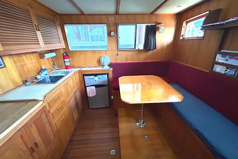 Slide: The Image of Cozy 1985 Sundowner Tug Princess Louisa interior with kitchenette and dining area. - 10