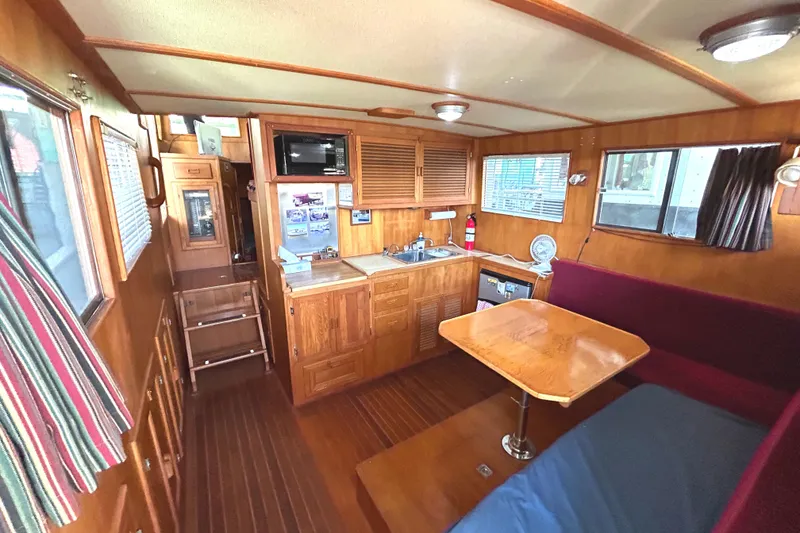 Slide: The Image of Interior of 1985 Sundowner Tug Princess Louisa, featuring wood paneling and compact kitchen area. - 11