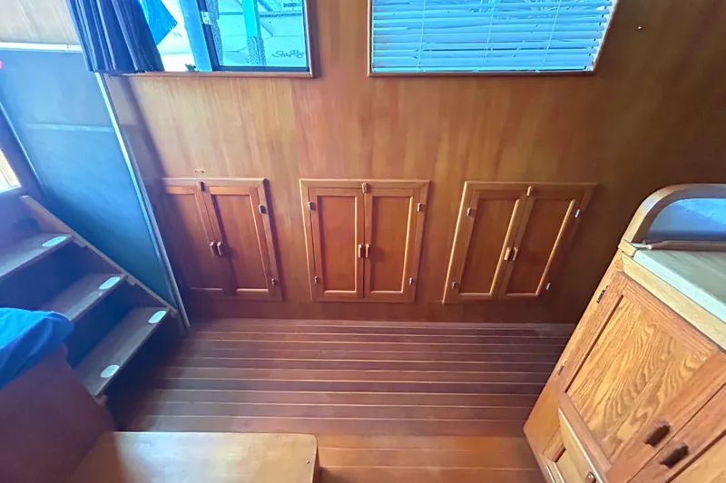Slide: The Image of Interior of 1985 Sundowner Tug Princess Louisa, featuring wooden cabinetry and flooring. - 14