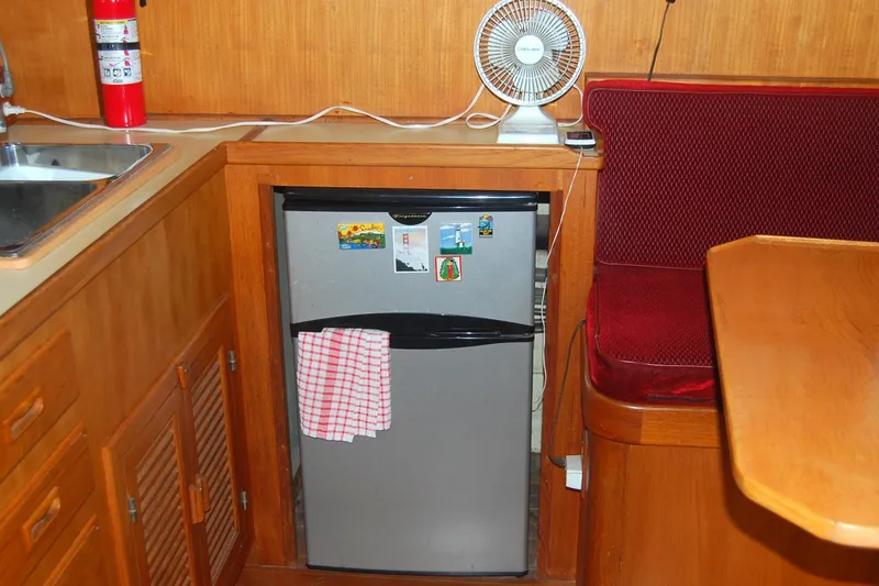 Slide: The Image of Compact kitchen area in 1985 Sundowner Tug Princess Louisa with fridge, fan, and seating. - 19