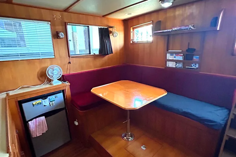Slide: The Image of Cozy 1985 Sundowner Tug Princess Louisa interior with dining area and compact kitchen. - 2