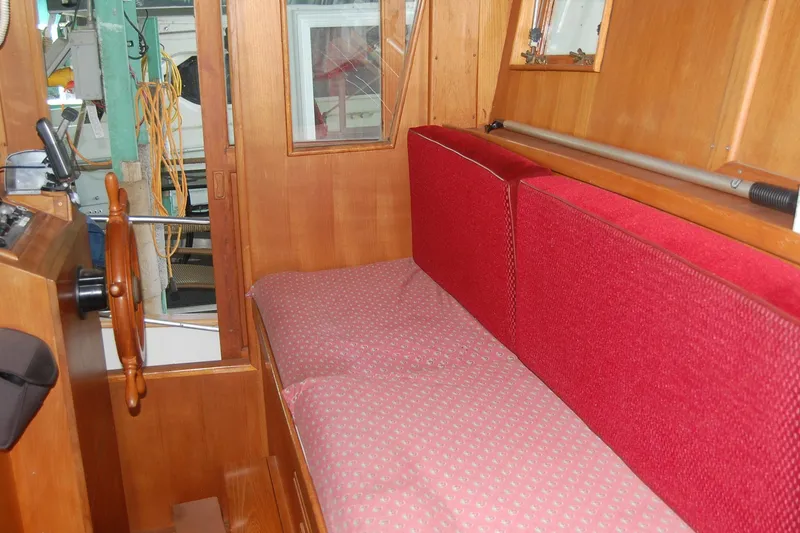 Slide: The Image of Interior of 1985 Sundowner Tug Princess Louisa with red seating and wooden helm. - 20