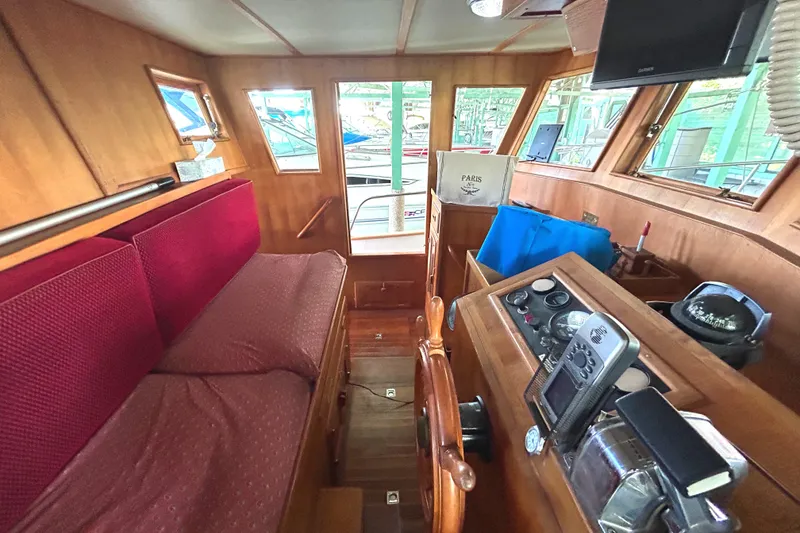 Slide: The Image of Interior of 1985 Sundowner Tug Princess Louisa, featuring wooden paneling and navigation equipment. - 21