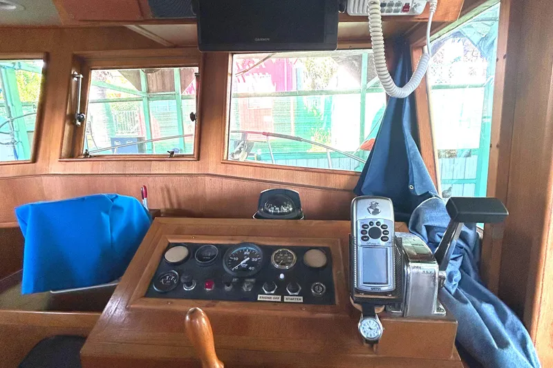 Slide: The Image of 1985 Sundowner Tug Princess Louisa helm with navigation instruments and wooden dashboard. - 24