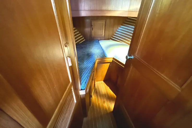 Slide: The Image of Cozy wooden cabin interior of 1985 Sundowner Tug Princess Louisa with striped bedding. - 29