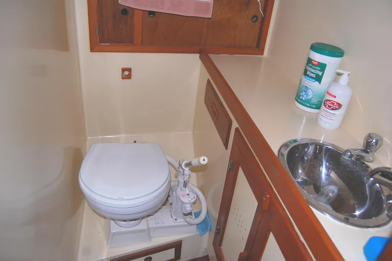 Slide: The Image of Compact bathroom in 1985 Sundowner Tug Princess Louisa, featuring toilet, sink, and storage. - 31