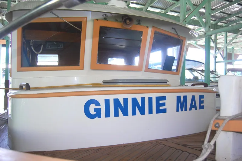 Slide: The Image of 1985 Sundowner Tug Princess Louisa, named "Ginnie Mae," docked in a covered marina. - 38