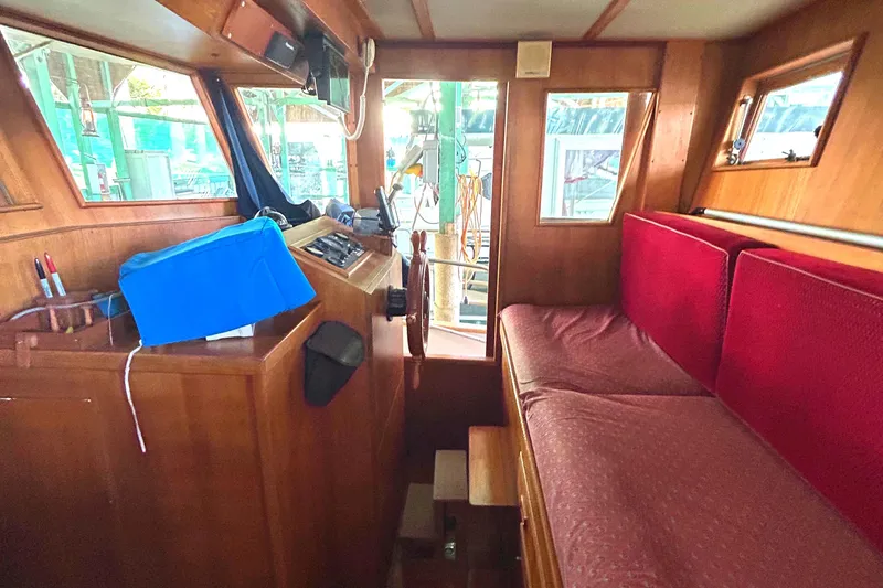 Slide: The Image of Interior of 1985 Sundowner Tug Princess Louisa with wooden paneling and red seating. - 4