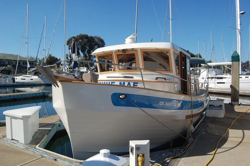 Slide: The Image of 1985 Sundowner Tug Princess Louisa docked at marina under clear blue sky. - 6