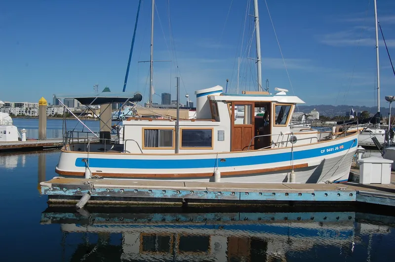 Slide: The Image of 1985 Sundowner Tug Princess Louisa docked in a marina under clear blue skies. - 9