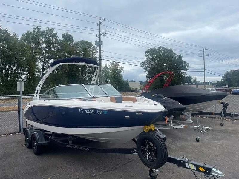 Slide: The Image of 2023 Chaparral 21 SSi boat on trailer, parked outdoors, overcast sky. - 10
