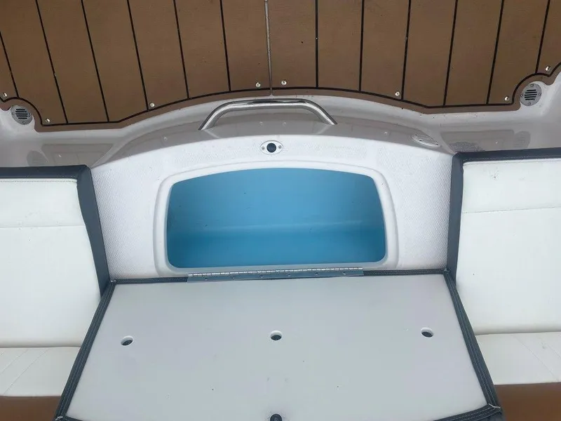 Slide: The Image of 2023 Chaparral 21 SSi boat storage compartment with open hatch, featuring white and blue interior. - 11