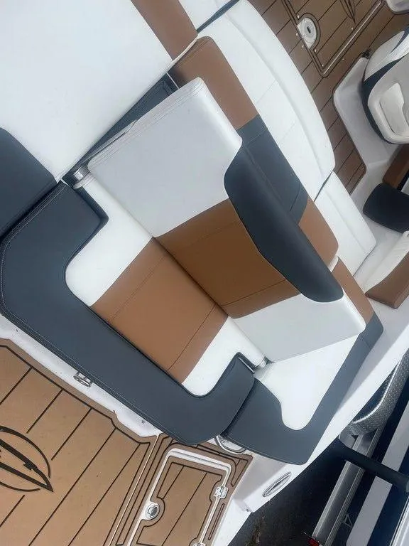 Slide: The Image of 2023 Chaparral 21 SSi boat interior with stylish brown, white, and gray seating. - 13