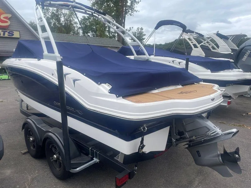 Slide: The Image of 2023 Chaparral 21 SSi boat with blue cover on trailer, parked outdoors. - 4