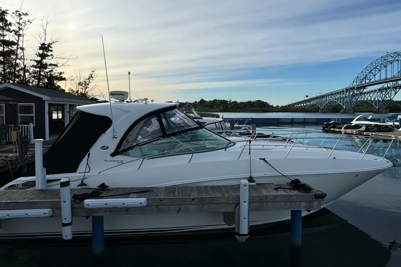 The Image of 2010 Sea Ray 370 Sundancer docked near a bridge, serene waterfront setting. - 0