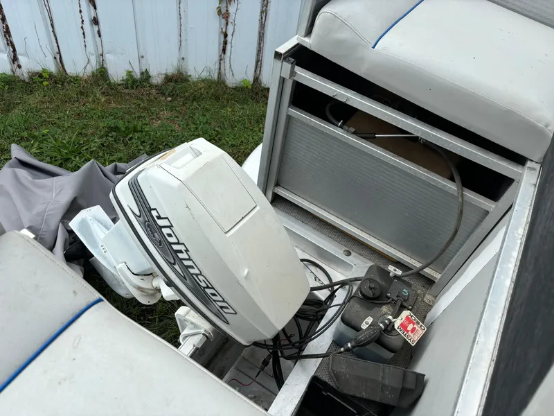 Slide: The Image of 1992 Harris FloteBote 240 Classic with Johnson outboard motor, open storage compartment. - 2