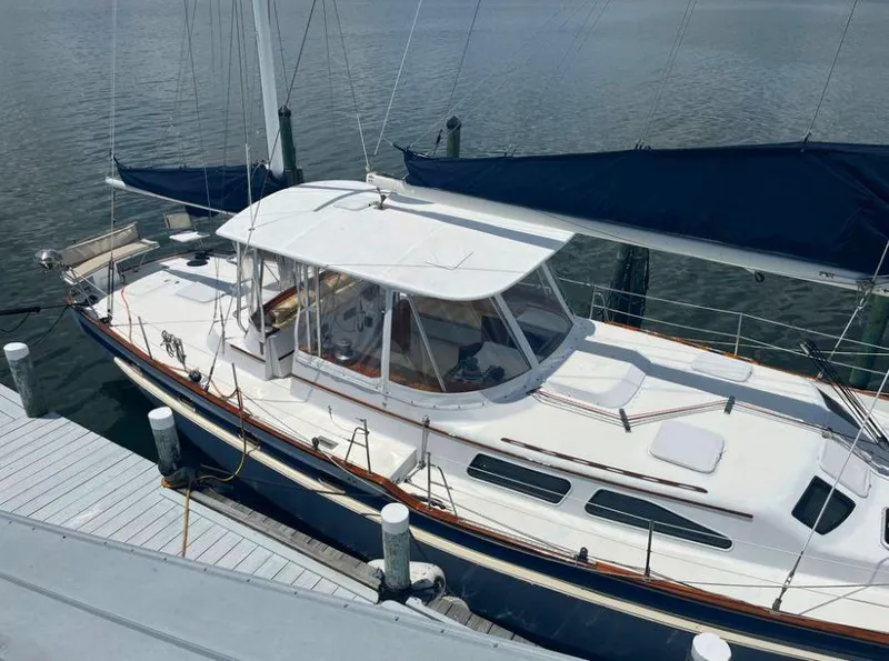 Slide: The Image of 1990 Irwin 54 sailboat docked at marina, featuring white deck and blue hull. - 16