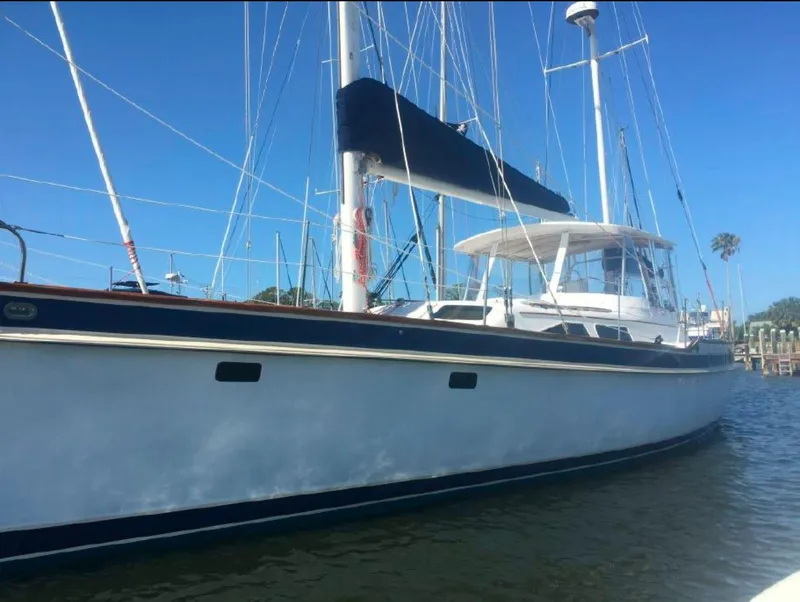 Slide: The Image of 1990 Irwin 54 sailboat with blue trim docked in sunny marina. - 2