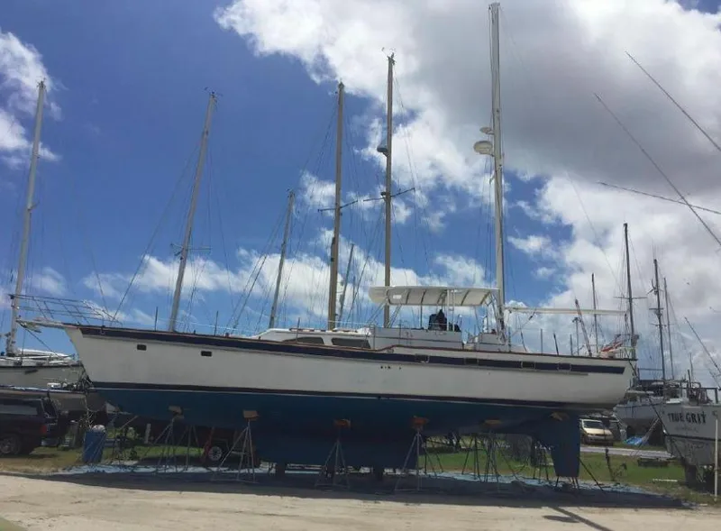 Slide: The Image of Irwin 54 sailboat from 1990 on dry dock under a partly cloudy sky. - 22