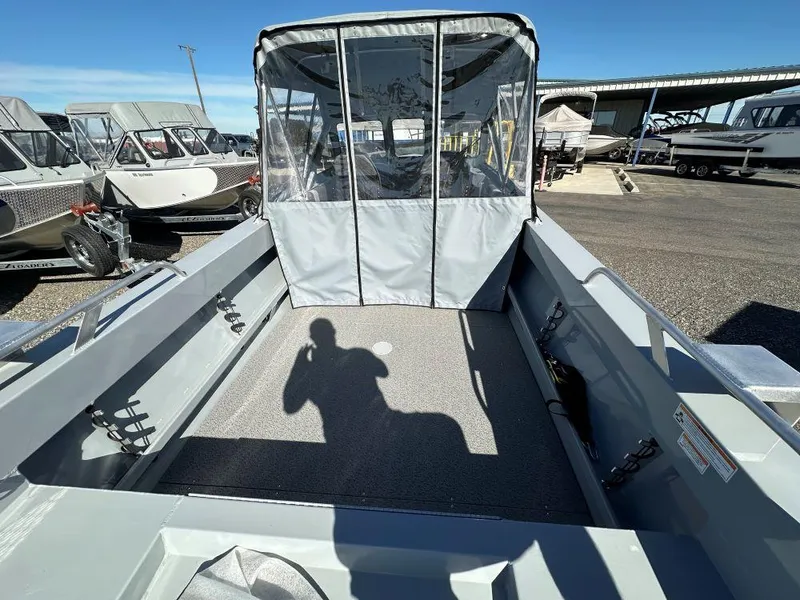 Slide: The Image of 2025 Hewescraft 200 Sportsman boat interior with canopy, parked in a marina. - 4