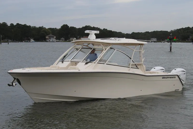 Slide: The Image of 2023 Grady-White Freedom 335 boat with Yamaha XTO outboard engines, docked under clear blue sky. - 2