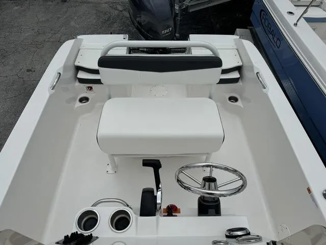 Slide: The Image of 2025 Robalo R160CC boat interior with steering wheel and seating. - 12