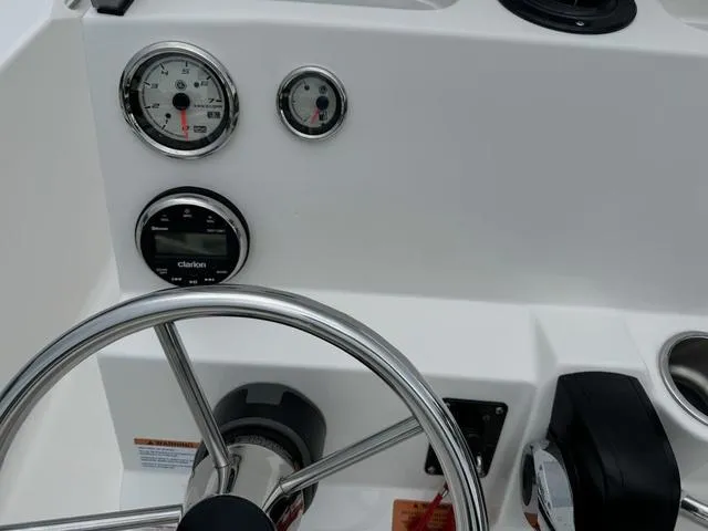 Slide: The Image of 2025 Robalo R160CC boat dashboard with steering wheel and gauges. - 19