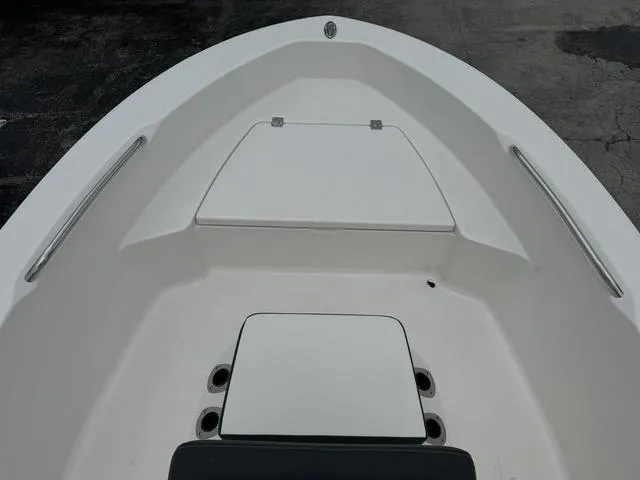 Slide: The Image of 2025 Robalo R160CC boat interior, featuring sleek white deck and storage compartments. - 7