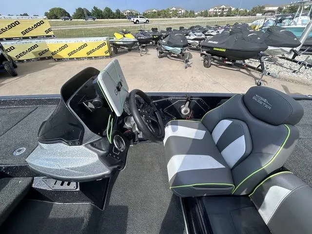 Slide: The Image of 2018 Skeeter ZX250 boat interior with steering wheel and seat, parked near Sea-Doo jet skis. - 19