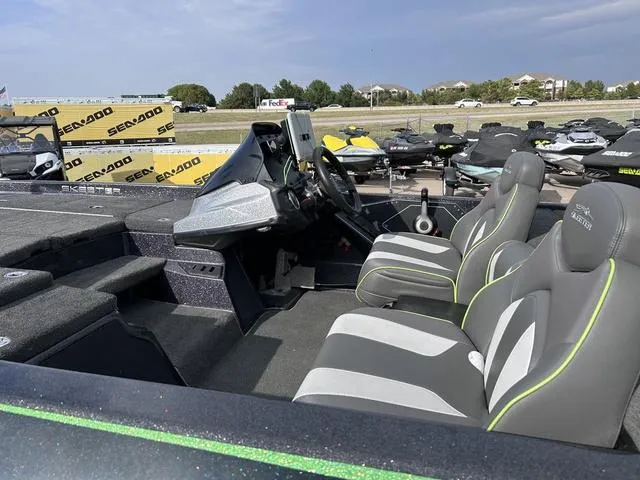 Slide: The Image of 2018 Skeeter ZX250 boat interior with gray and green seats, parked near Sea-Doo jet skis. - 6
