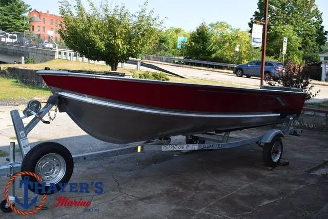 Slide: The Image of 2025 Lund SSV-16 Tiller boat on trailer, red and silver, parked outdoors. - 8