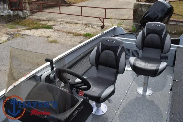 Slide: The Image of 2025 Lund 1600 Fury SS boat interior with two black seats and steering console. - 19