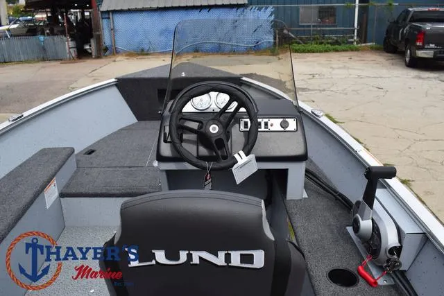 Slide: The Image of 2025 Lund 1600 Fury SS boat interior with steering wheel and dashboard, Thayer's Marine logo. - 22