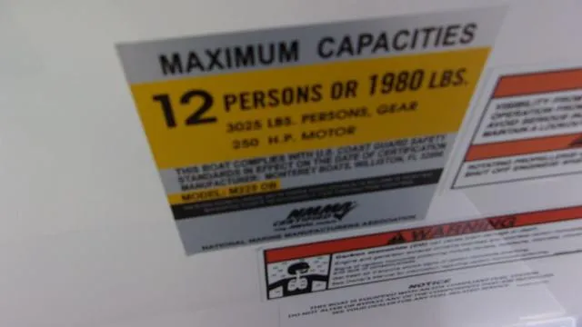 Slide: The Image of Capacity label for 2023 Monterey M-225: 12 persons or 1980 lbs, 250 HP motor. - 12