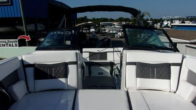 Slide: The Image of 2023 Monterey M-225 boat interior with white and black seating, docked at a marina. - 3