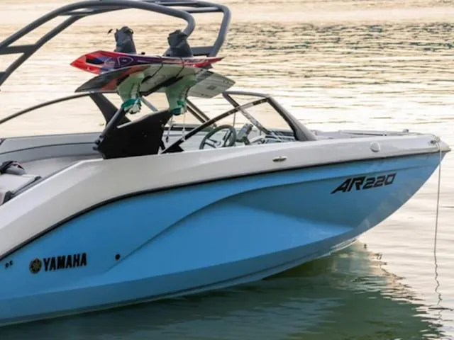 Slide: The Image of 2025 Yamaha AR220 boat on water with wakeboards attached. - 1