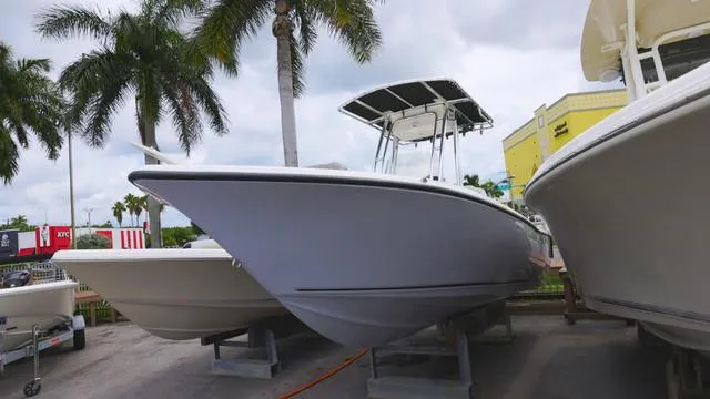 Slide: The Image of 2025 Key West 203 FS boat displayed outdoors with palm trees in the background. - 1