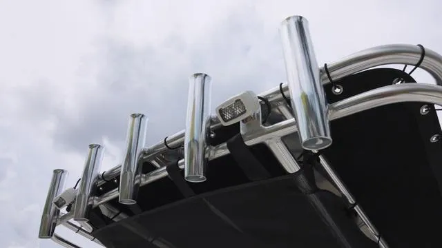 Slide: The Image of Key West 203 FS 2025 boat rod holders against cloudy sky. - 16
